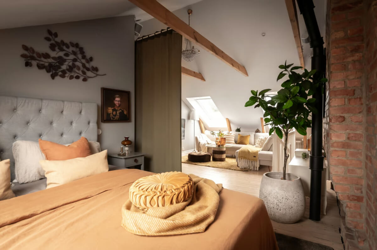 attic bedroom with sitting area and warm colored textiles