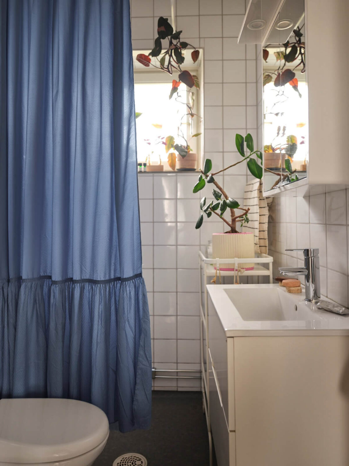 A 1940s Swedish Apartment with a Soft Yellow Kitchen 19 bathroom blue shower curtain