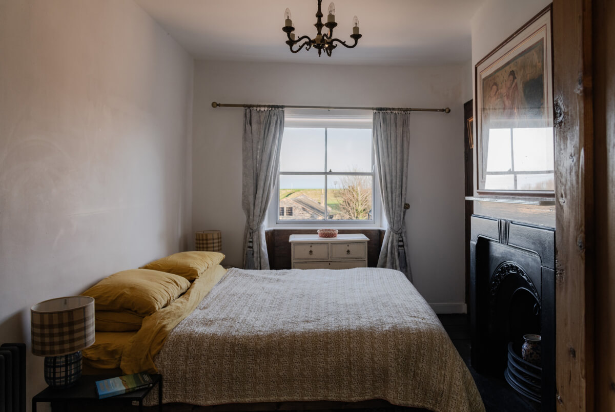 A Georgian English House Restored To Its Former Glory 20 bedroom with fireplace and light gray walls