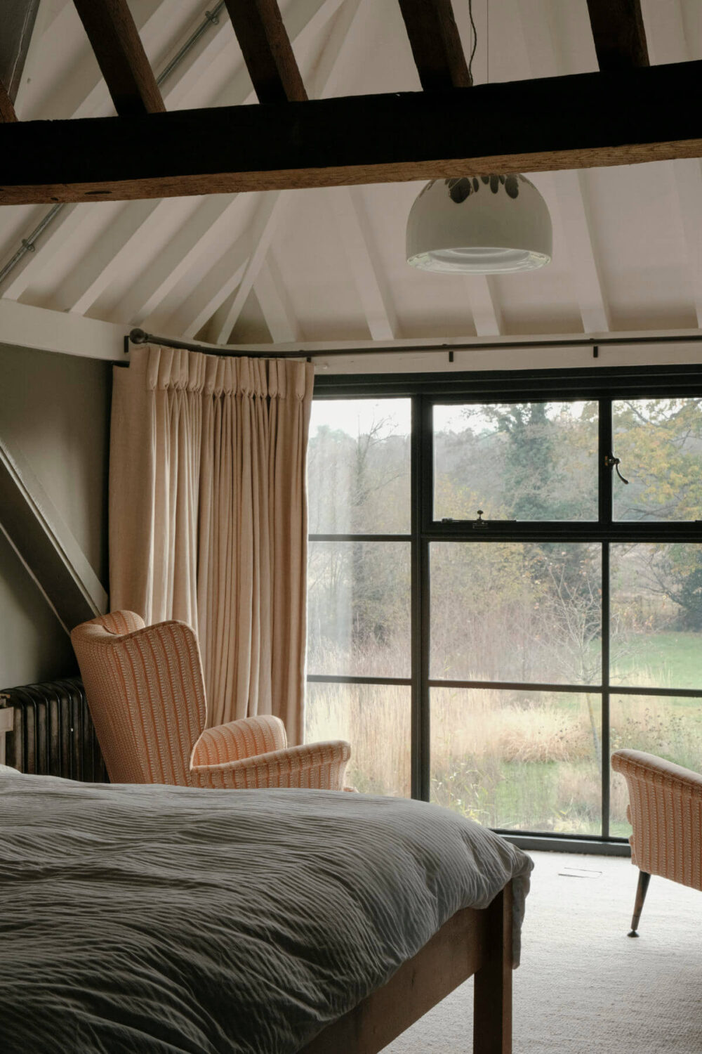 A Barn House with Vintage Decor and Exposed Beams 23 bedroom with pitched ceiling and exposed beams