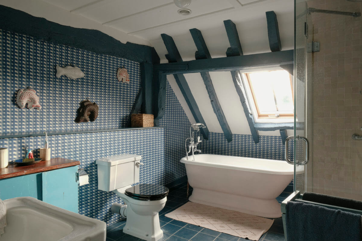 A Barn House with Vintage Decor and Exposed Beams 33 blue bathroom with slanted ceiling and freestanding bath