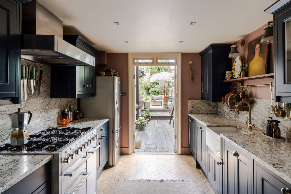 A Victorian Home with a Rich Color Palette and a Beautiful Garden 6 blue kitchen herringbone floor garden doors