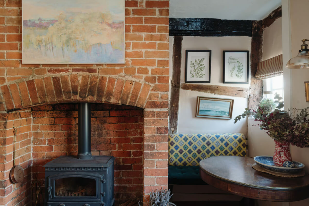A Historic English Cottage Decorated in Pink & Blue Tones 4 brick fireplace built-in seating niche cottage living room