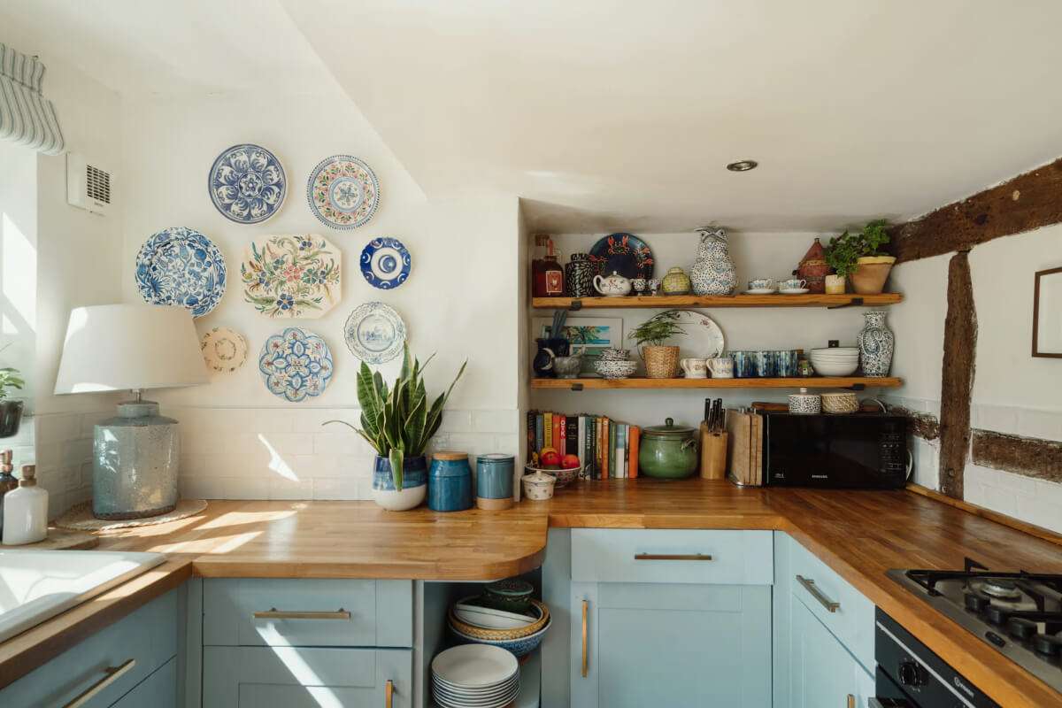 A Historic English Cottage Decorated in Pink & Blue Tones 6 charming blue cottage kitchen wooden shelves plates wall decor
