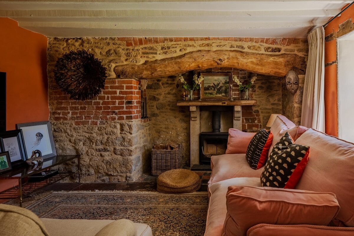 cottage living room with brick fireplace and orange walls nordroom