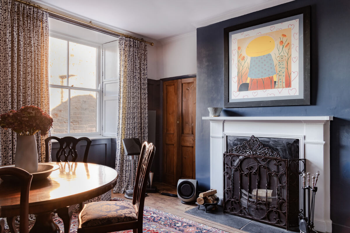 A Georgian English House Restored To Its Former Glory 1 dining room with dark blue walls round table and fireplace