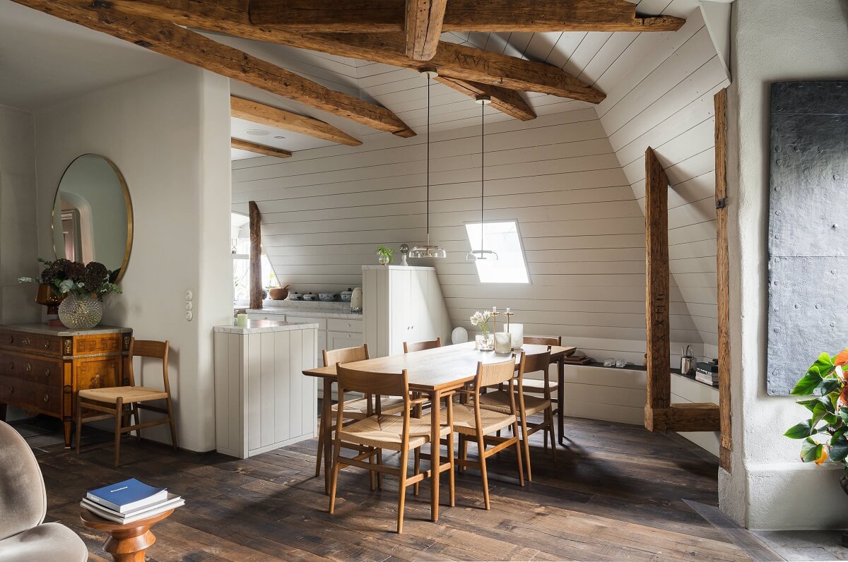 A Stylish Penthouse Apartment with Exposed Beams 9 dining space slanted ceiling exposed wooden beams
