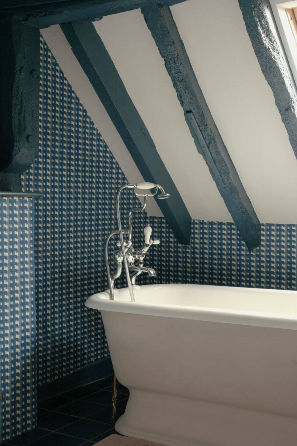 A Barn House with Vintage Decor and Exposed Beams 34 freestanding bath in blue bathroom with slanted ceiling and blue painted beams