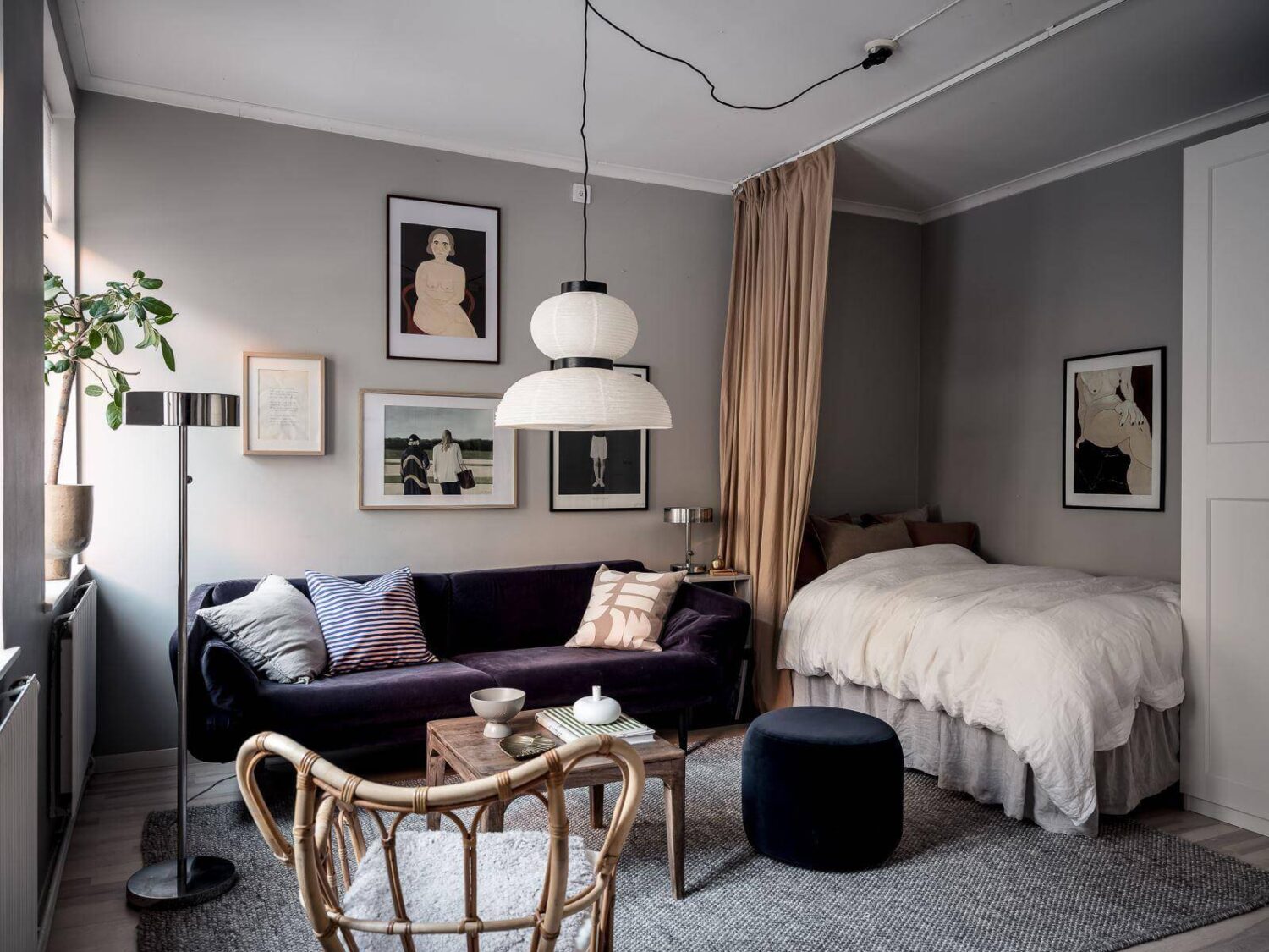 A Cozy Monochrome Gray Studio Apartment 1 gray scandinavian studio apartment purple sofa curtain room divider nordroom