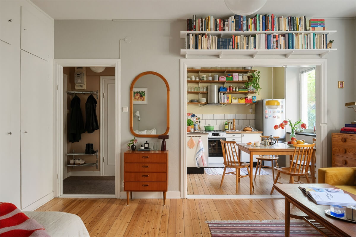 Midcentury Design and Colorful Decor in a Charming Studio Apartment 8 gray studio apartment bookshelves above doorframe built-in wardrobes