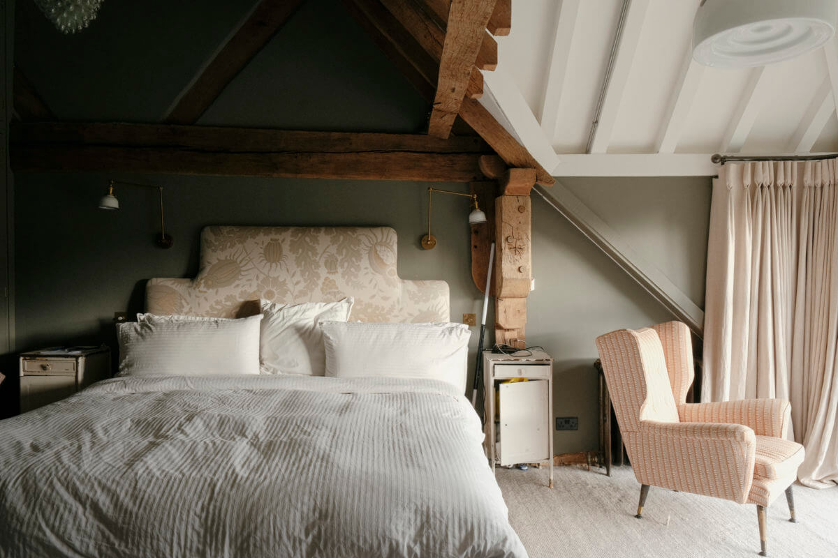 A Barn House with Vintage Decor and Exposed Beams 22 green bedroom with wood framework