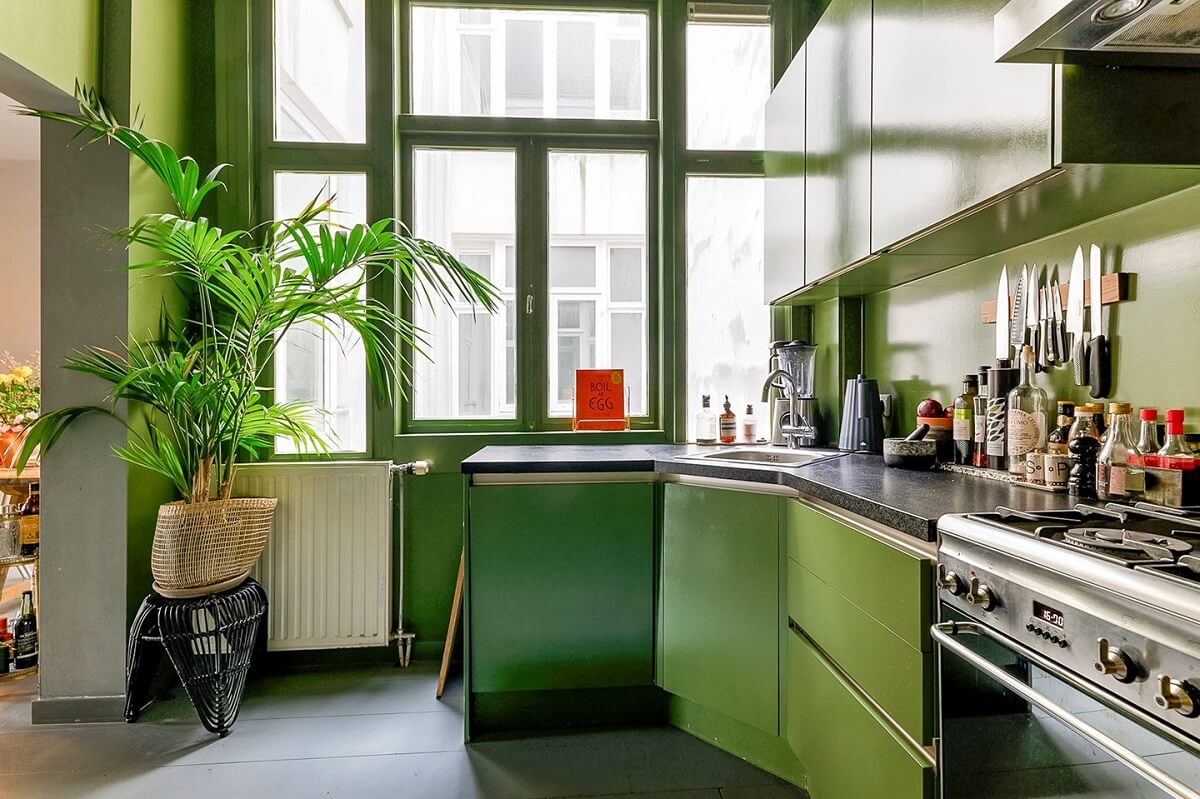 An Amsterdam Apartment with Surprising Bold Color Accents 9 green kitchen