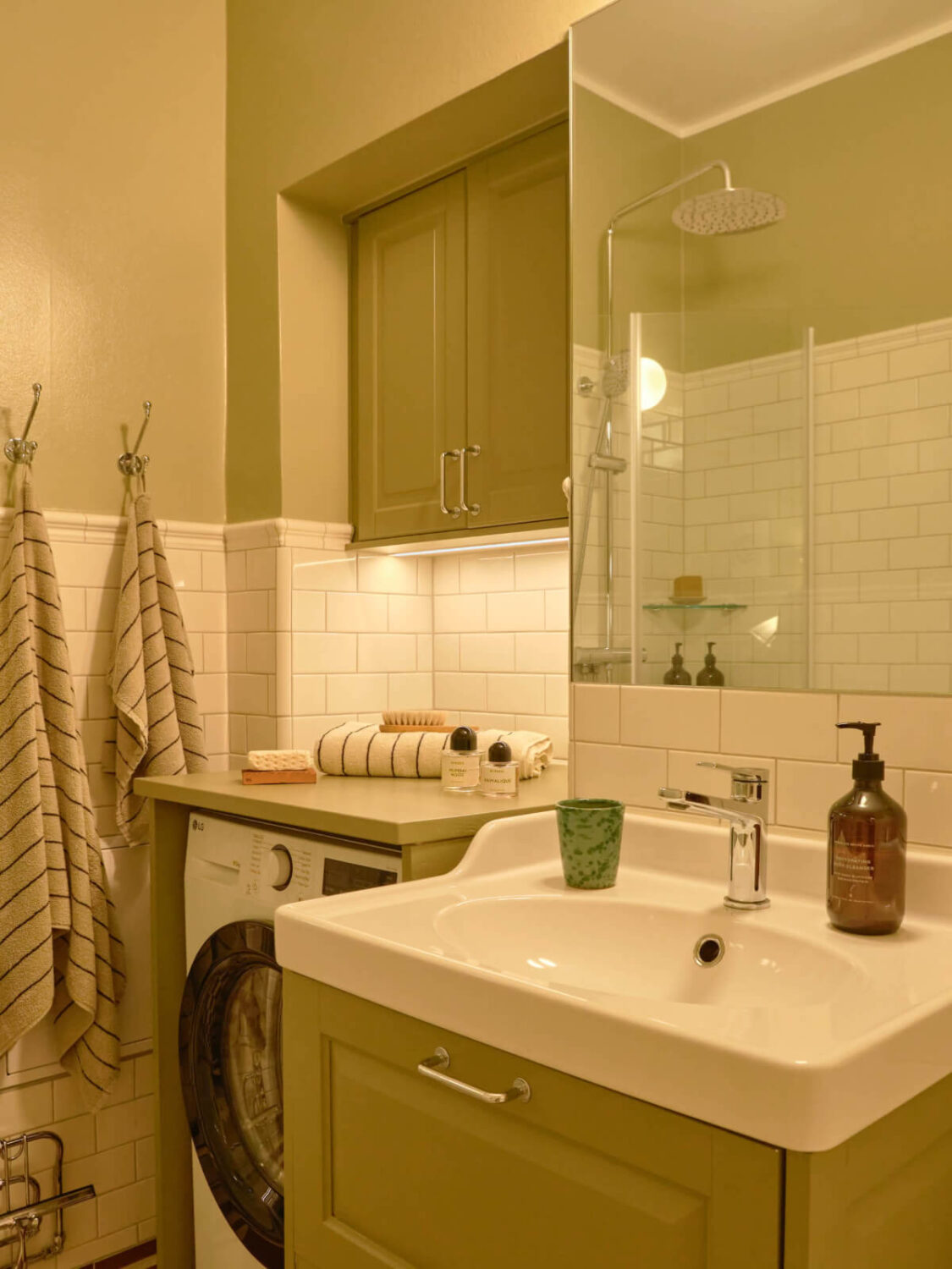 A Beautiful Color Palette and Historic Elements in a Stockholm Apartment 28 green walls and cabinets bathroom