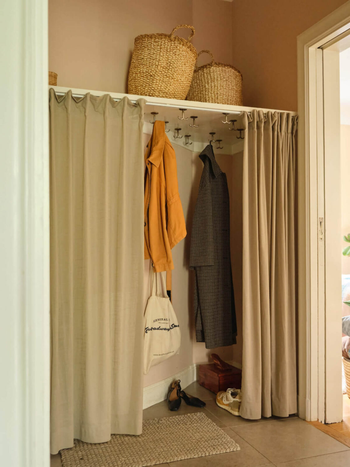 A Beautiful Color Palette and Historic Elements in a Stockholm Apartment 29 hall with storage behind curtain