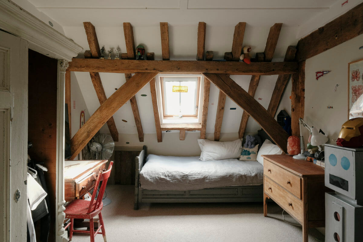A Barn House with Vintage Decor and Exposed Beams 37 kids bedroom with slanted ceiling and wooden beams