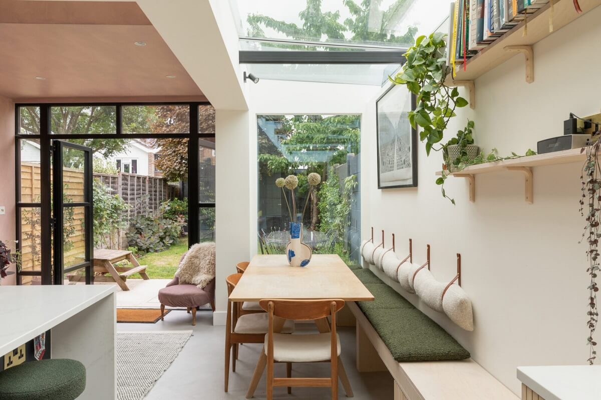 A London Family Home with a Light Modern Extension 2 kitchen dining table with green bench and skylight nordroom