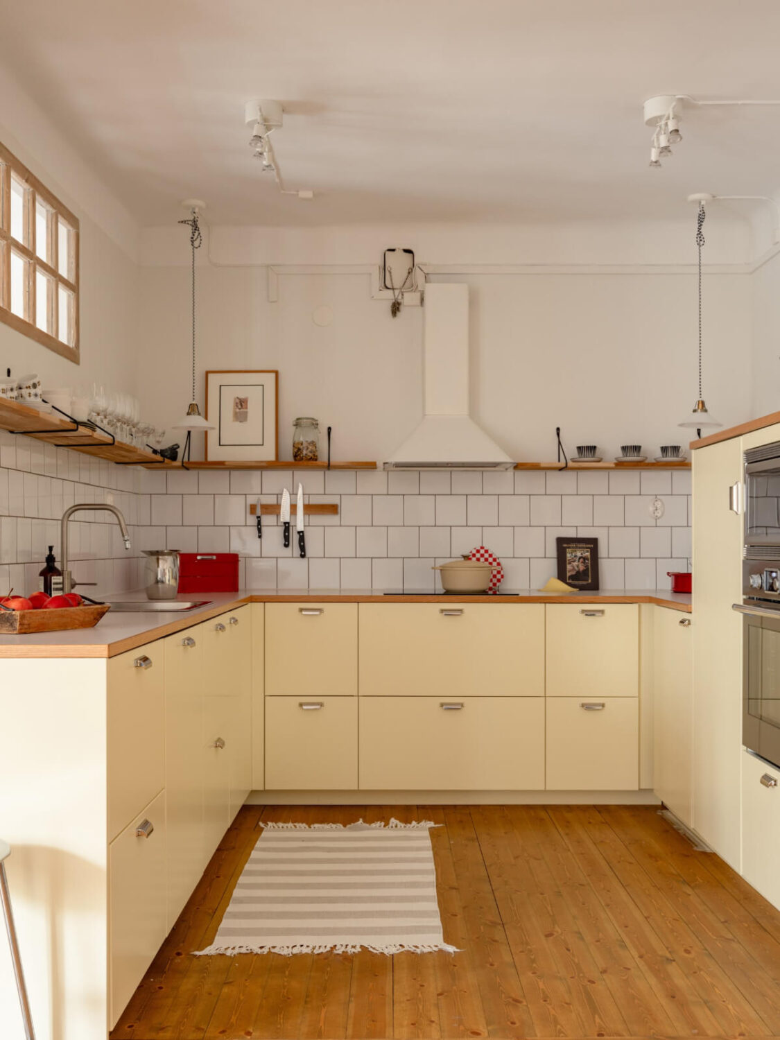 A Light Corner Apartment with a Pale Yellow Kitchen 11 kitchen pale yellow cabinets wooden countertop
