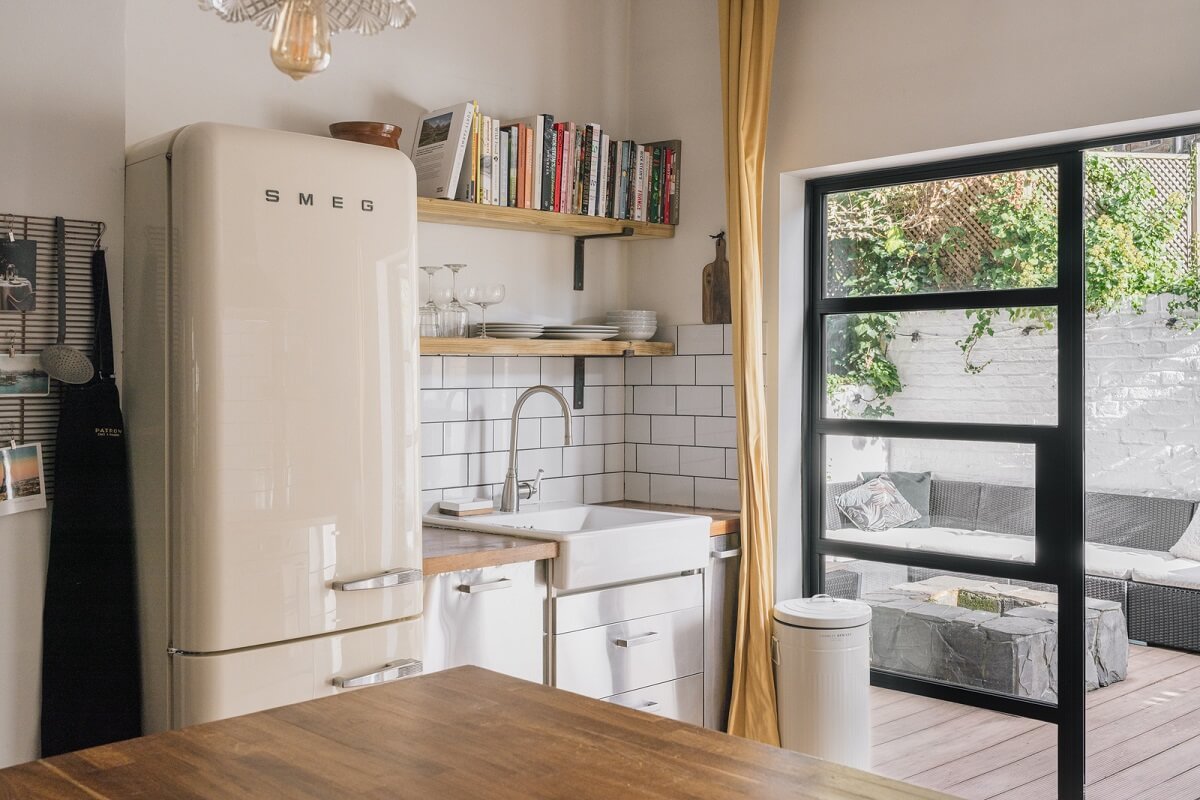 A Charming One-Bedroom Apartment with a Courtyard Terrace 4 kitchen with white tiles shelves and stainless steel cabinets