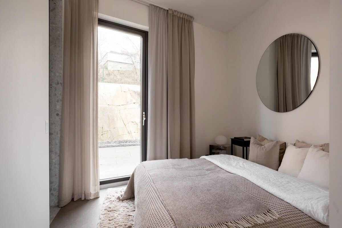 A Luxurious Architect-Designed Villa in Sweden 22 light colored bedroom with round mirror