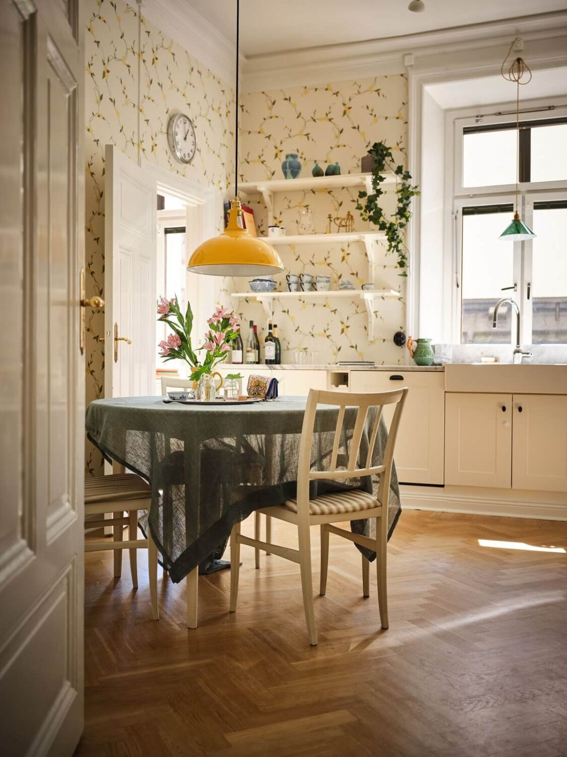 The Color Trends for 2025: Warm, Natural Shades and a Cheerful Accent 58 light cottage style kitchen with floral wallpaper round table and herringbone floor nordroom