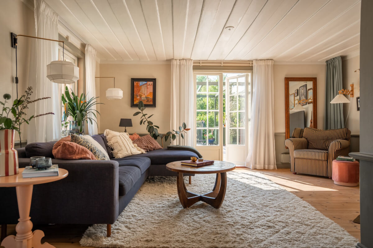 A Charming Historic Country House North of Stockholm 5 living room blue sofa wooden ceiling