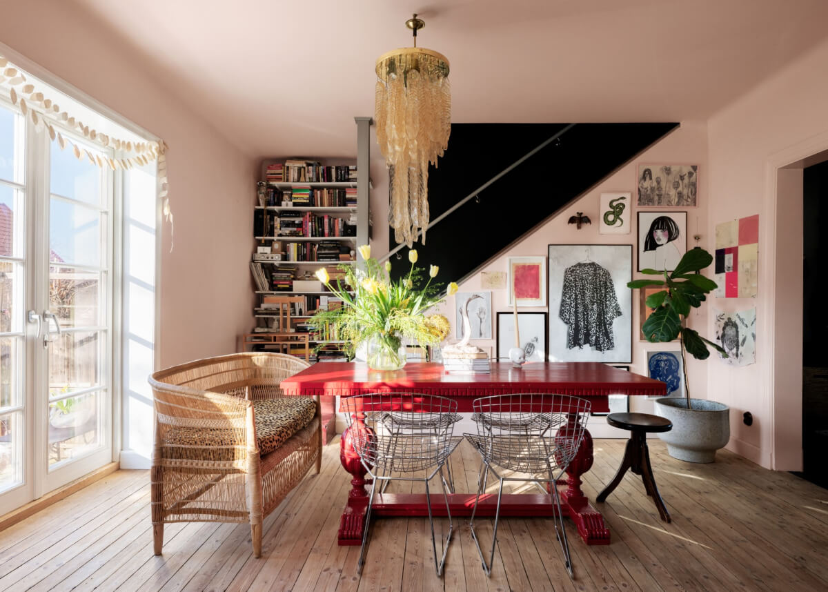 living room pink walls red dining table gallery wall