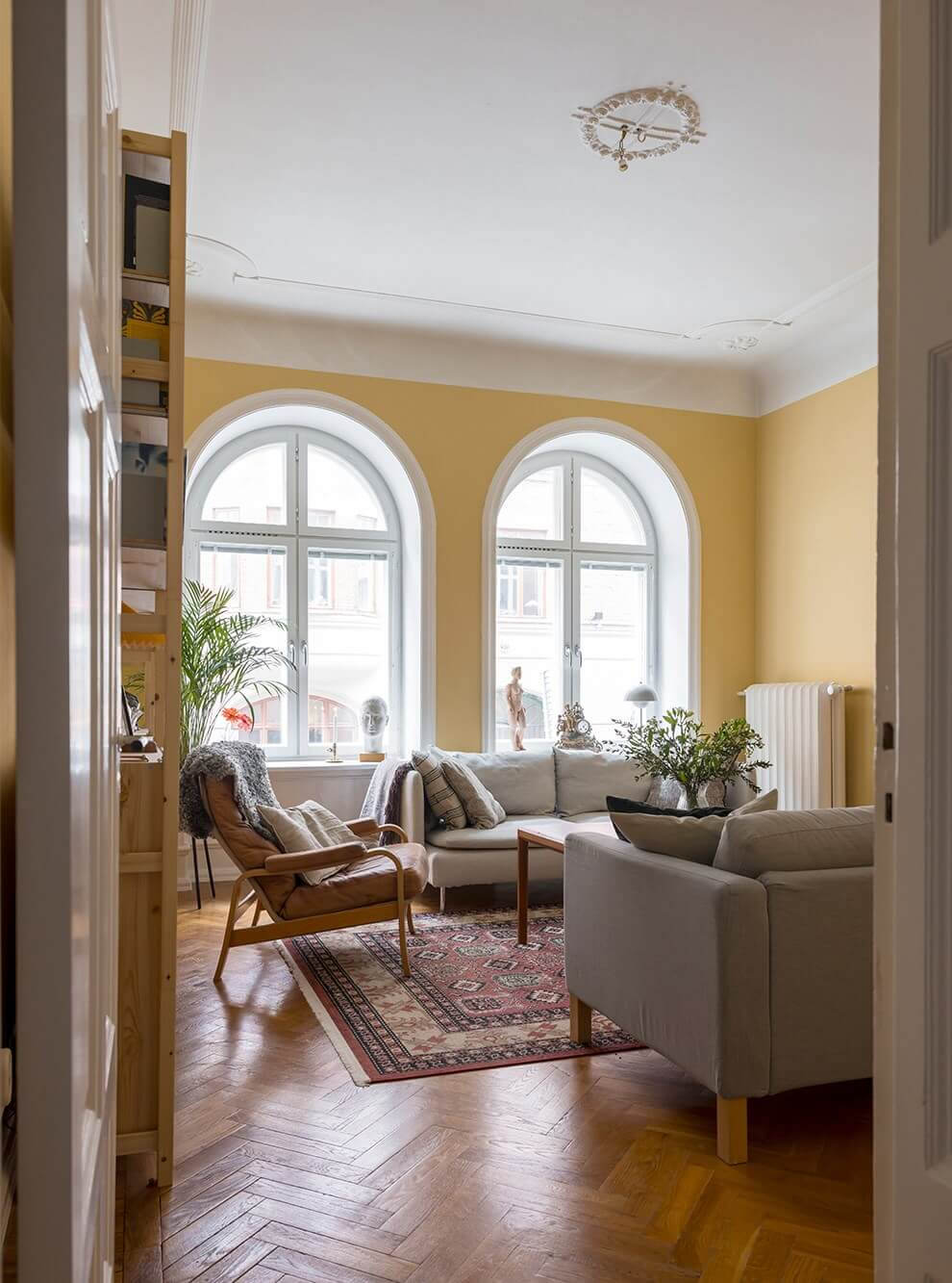 The Color Trends for 2025: Warm, Natural Shades and a Cheerful Accent 7 living room with yellow walls arched windows and parquet herringbone floor nordroom