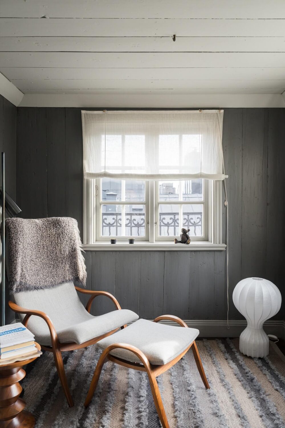 A Stylish Penthouse Apartment with Exposed Beams 14 lounge chair gray walls reading nook