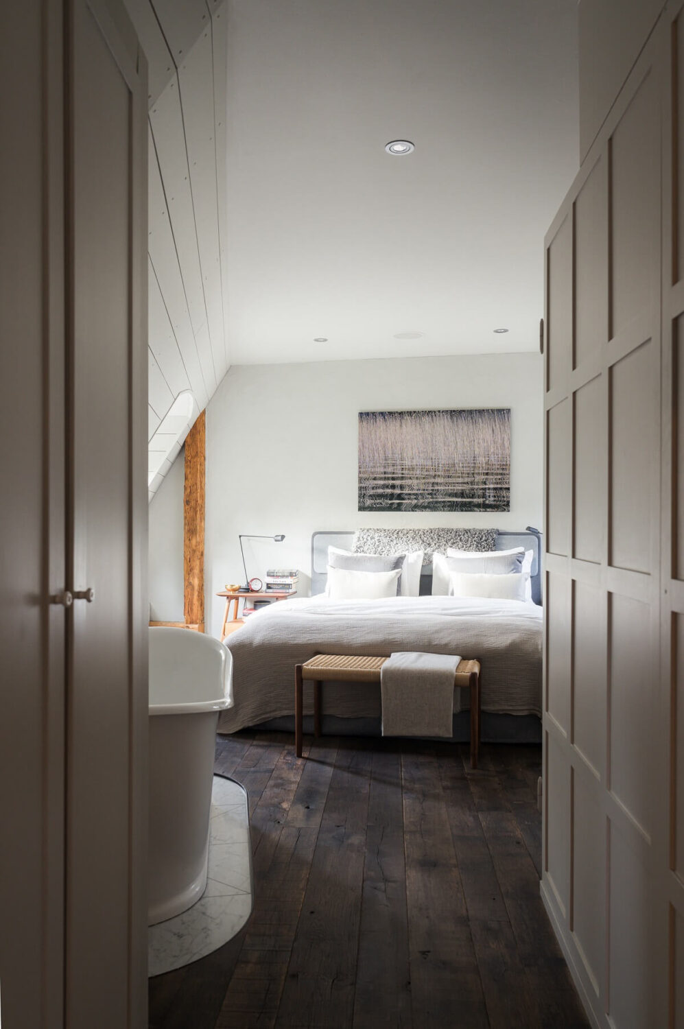 A Stylish Penthouse Apartment with Exposed Beams 19 master bedroom wooden floor freestanding bath