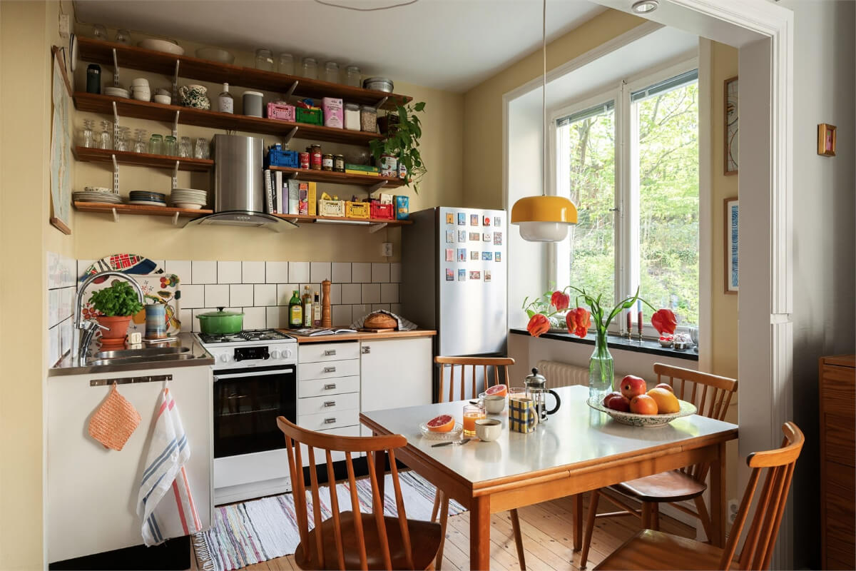 Midcentury Design and Colorful Decor in a Charming Studio Apartment 10 midcentury-swedish-kitchen-beige-walls-formica-table-wooden-shelves-nordroom