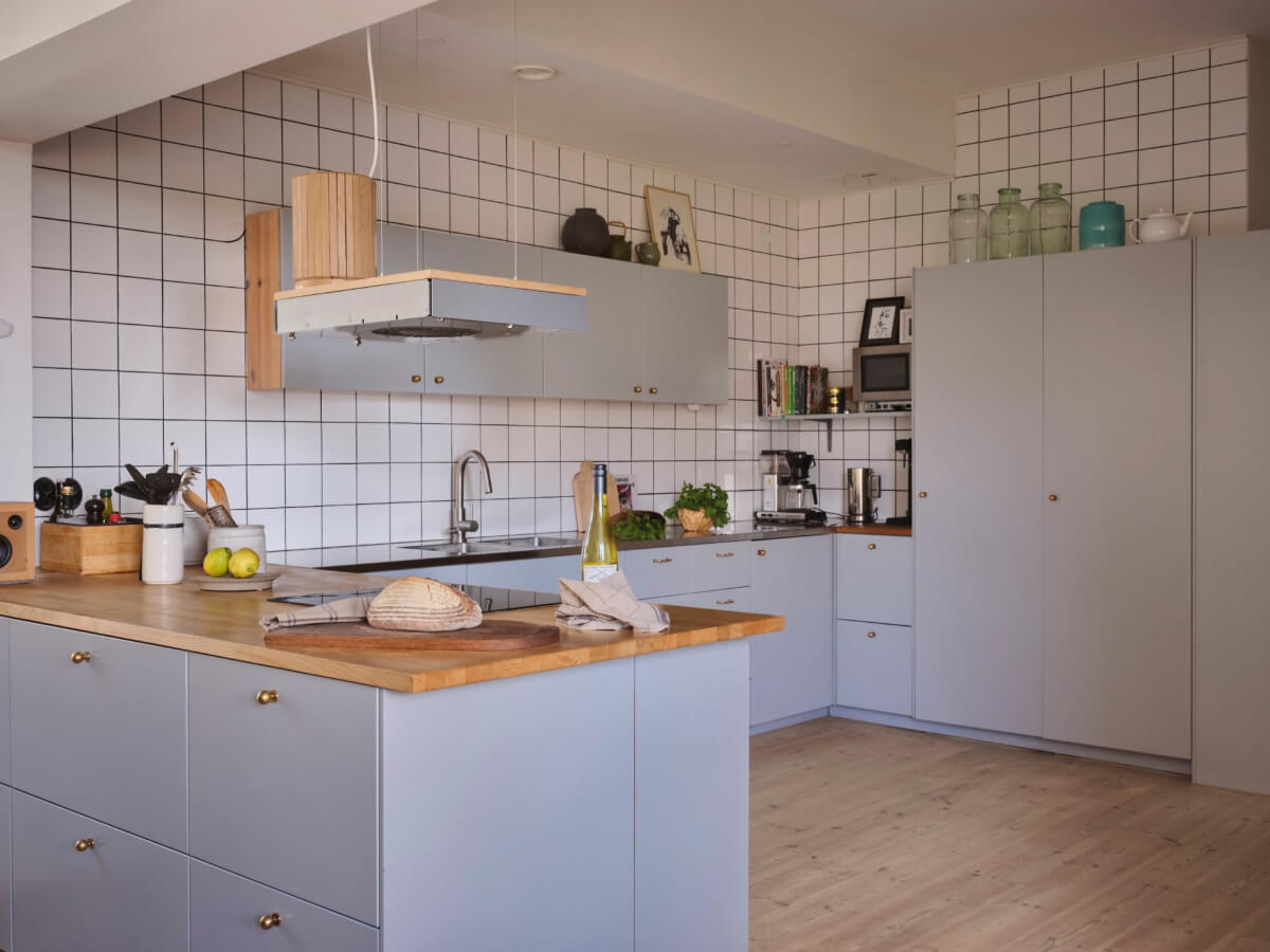 A Bright Family Apartment in a 1950s School Building 5 modern light gray kitchen brass knobs white tiles