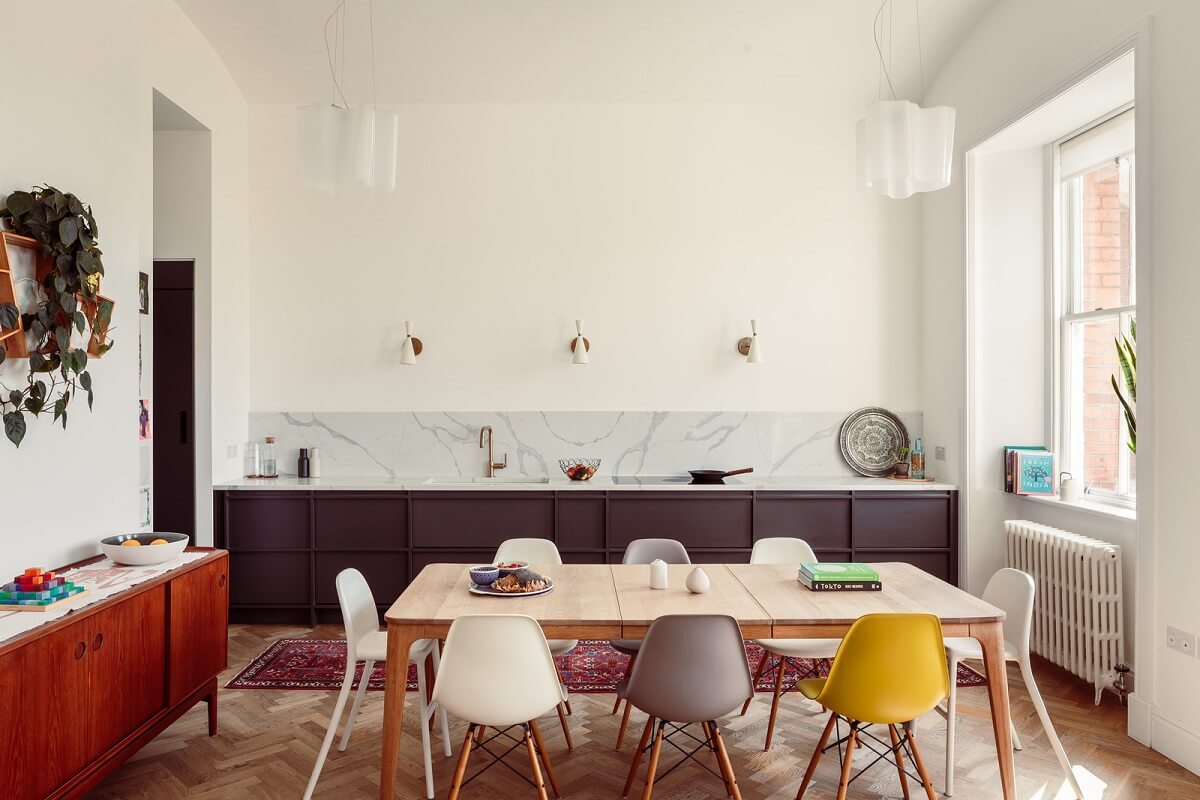 The Color Trends for 2025: Warm, Natural Shades and a Cheerful Accent 43 purple kitchen and large dining table with colorful eames chairs nordroom