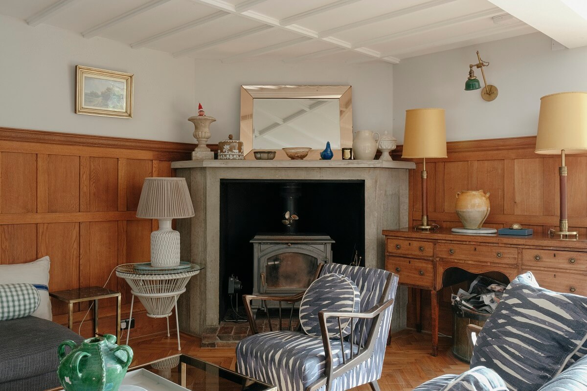 A Barn House with Vintage Decor and Exposed Beams 18 sitting room with fireplace and paneled walls