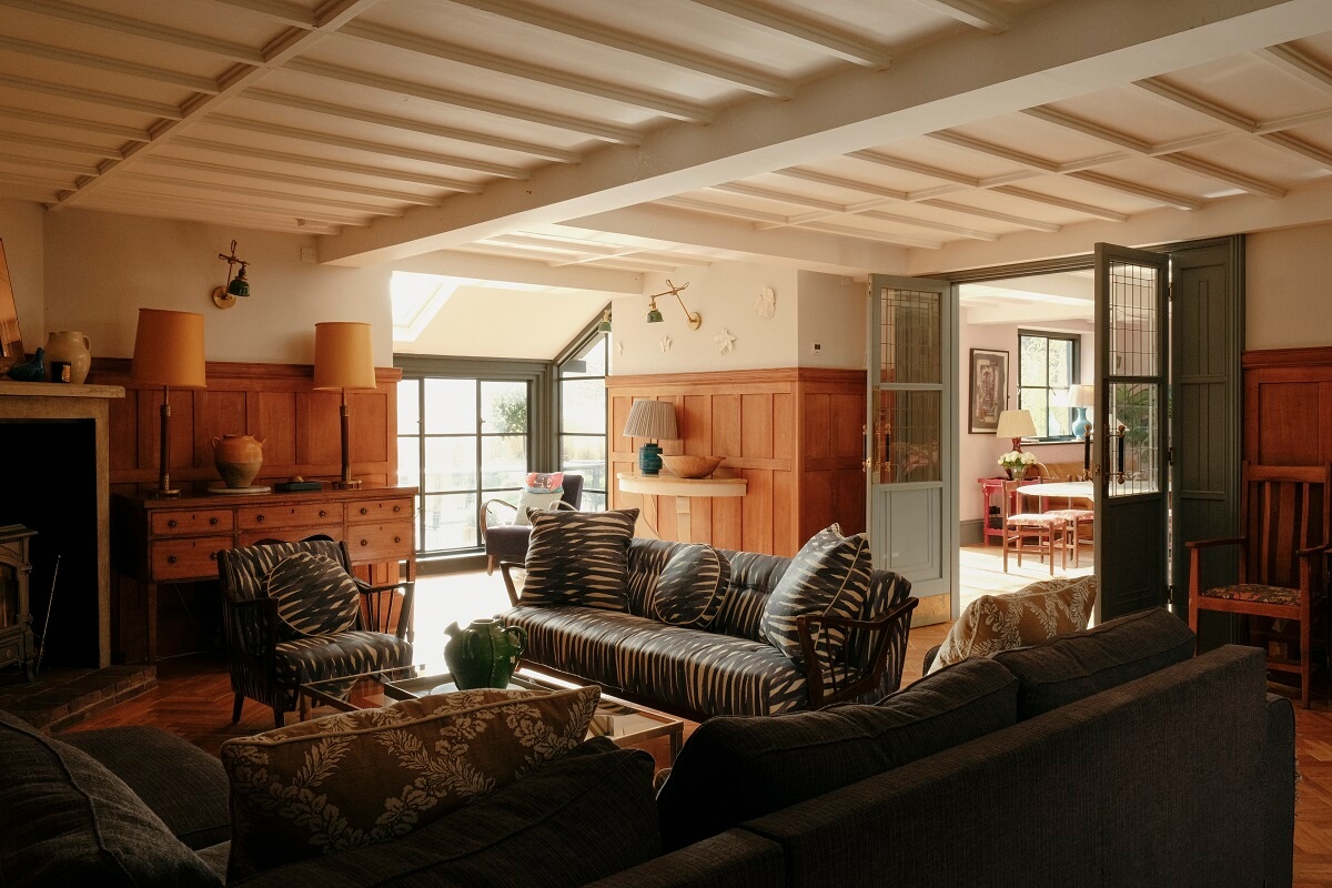 A Barn House with Vintage Decor and Exposed Beams 17 sitting room with low wooden ceiling and paneled walls