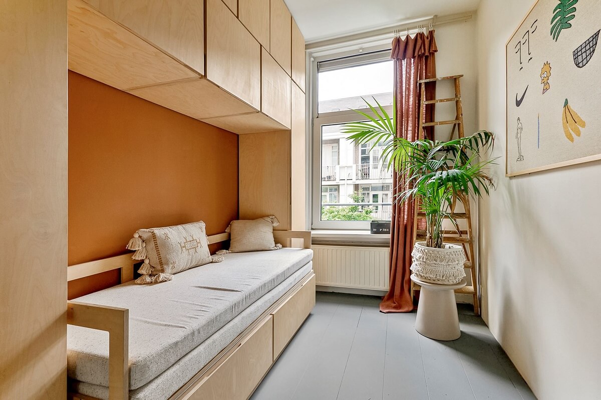 An Amsterdam Apartment with Surprising Bold Color Accents 16 small bedroom with orange feature wall and wall mounted storage