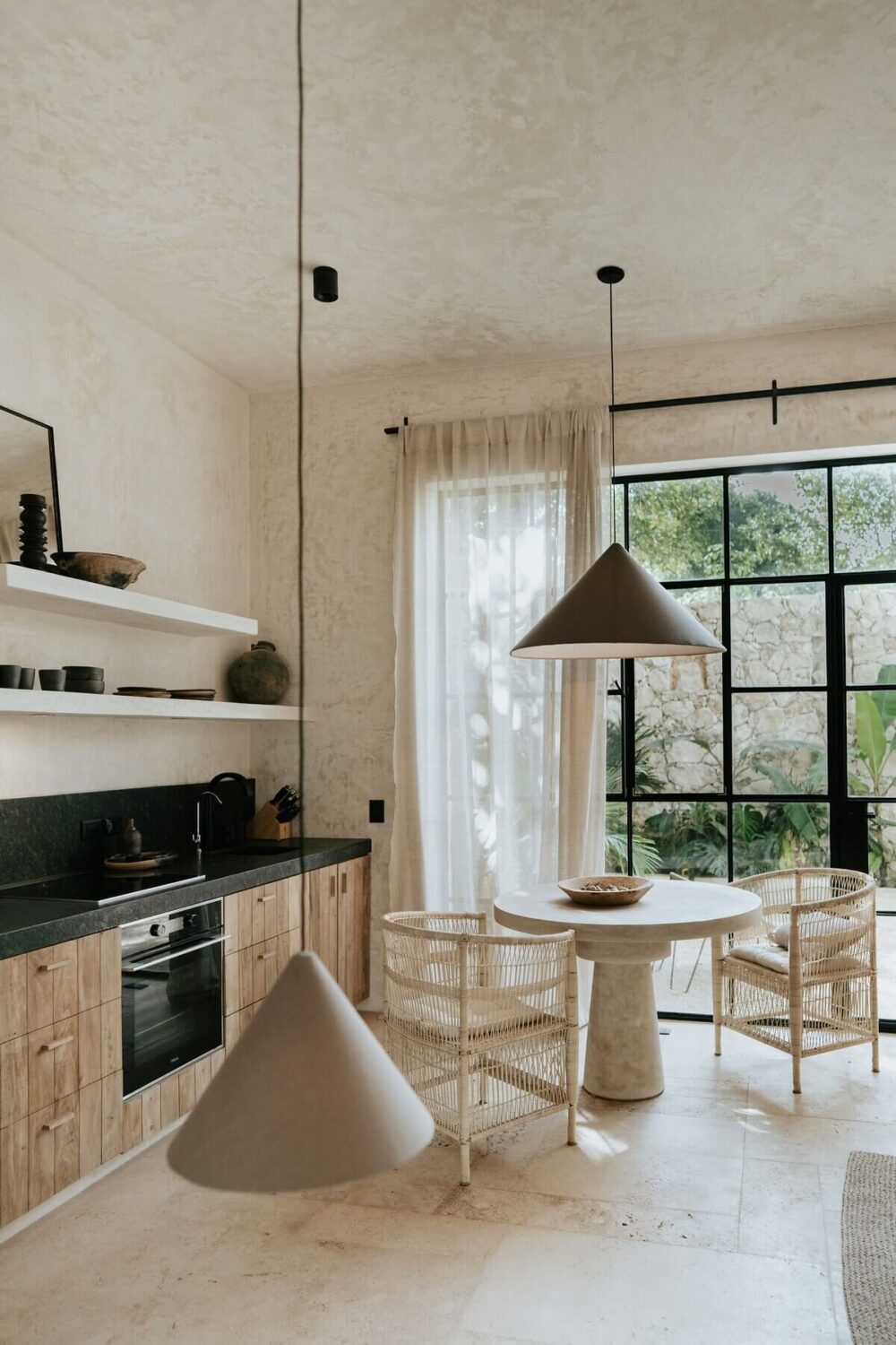 A Serene Design Apartment in Tulum 16 small-wooden-kitchen-shelves-round-dining-table-wicker-chairs-nordroom