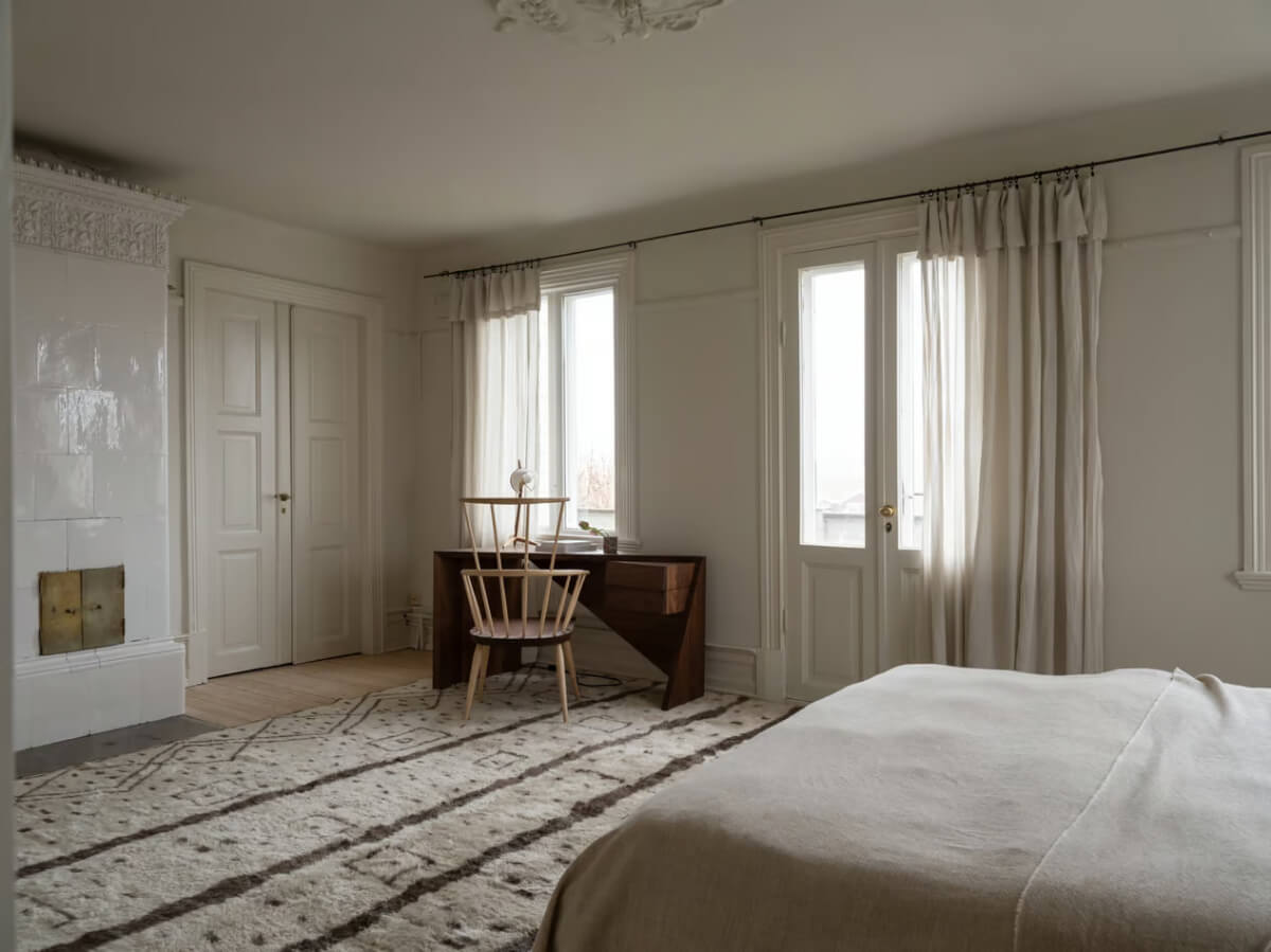 spacious bedroom with fireplace and desk
