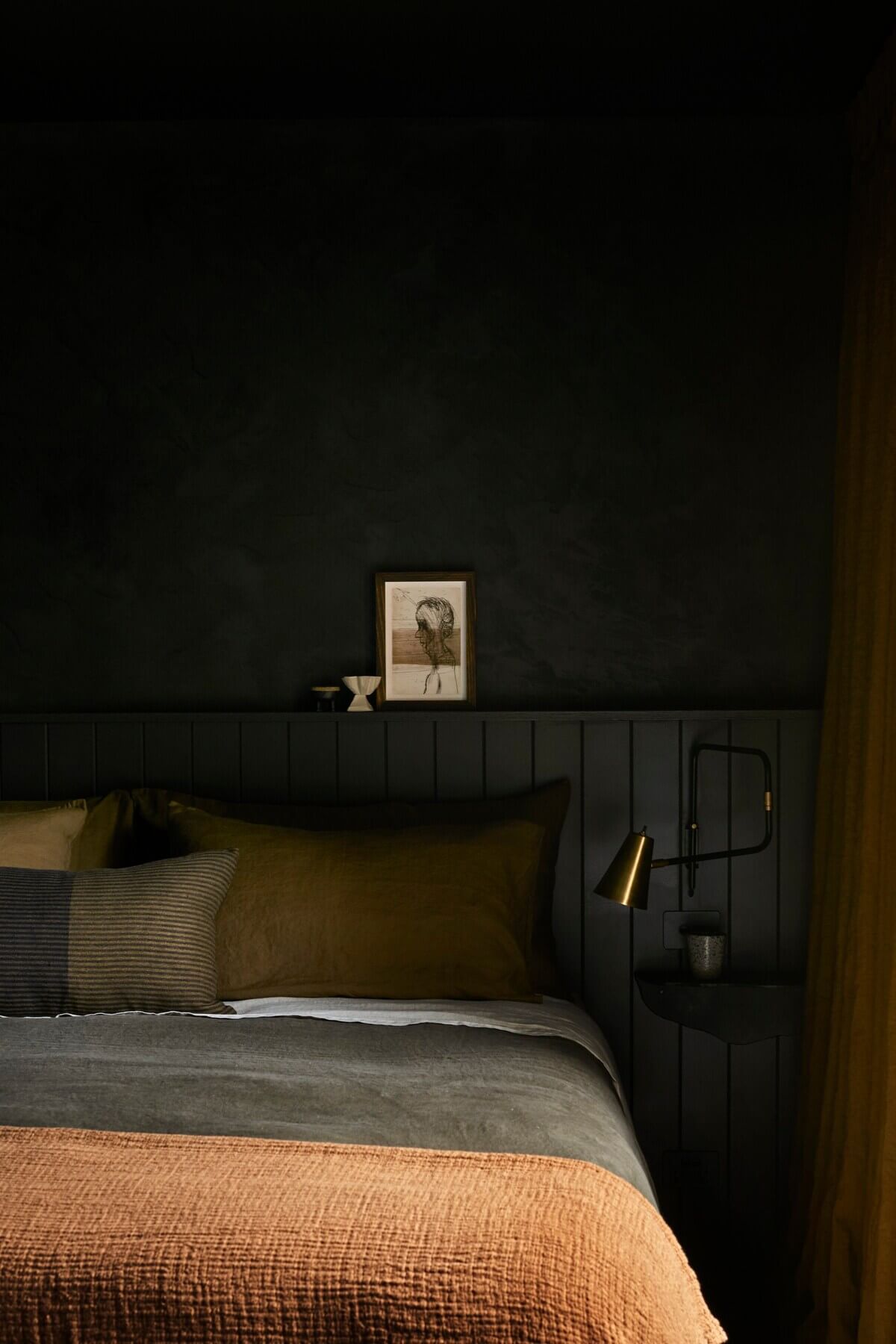 studio-apartment-black-walls-headboard-earthy-color-textiles-airbnb-nordroom