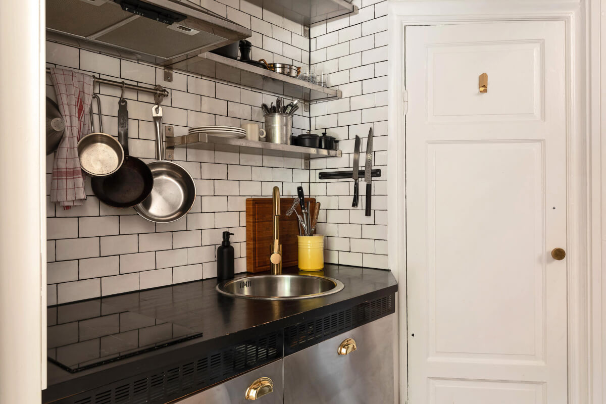 A Charming Studio Apartment with Leafy Courtyard Views 7 tiny kitchen white subway tiles stainless steel shelves