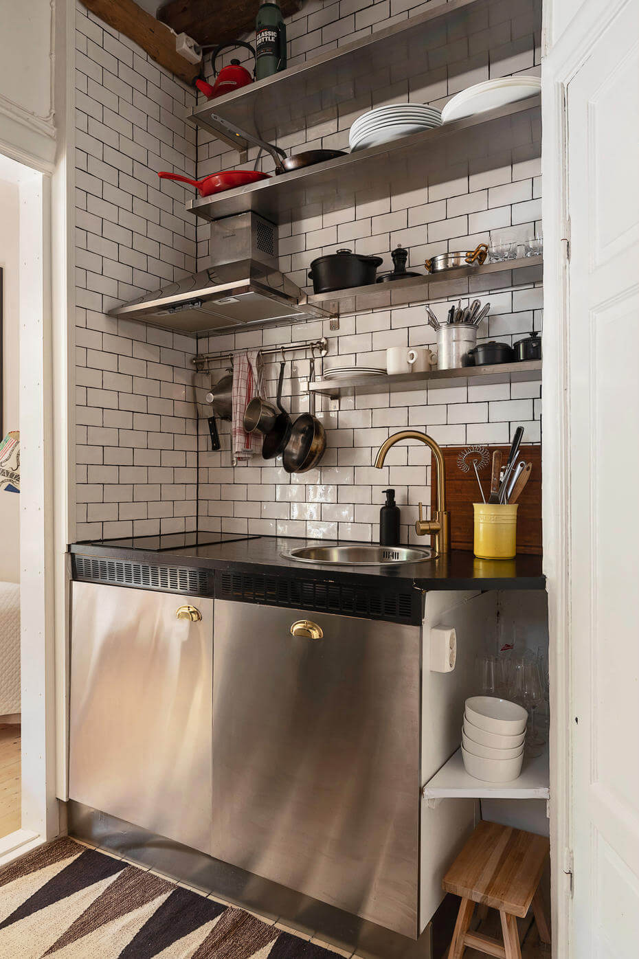 A Charming Studio Apartment with Leafy Courtyard Views 8 tiny stainless steel kitchen white subway tiles wooden beams nordroom