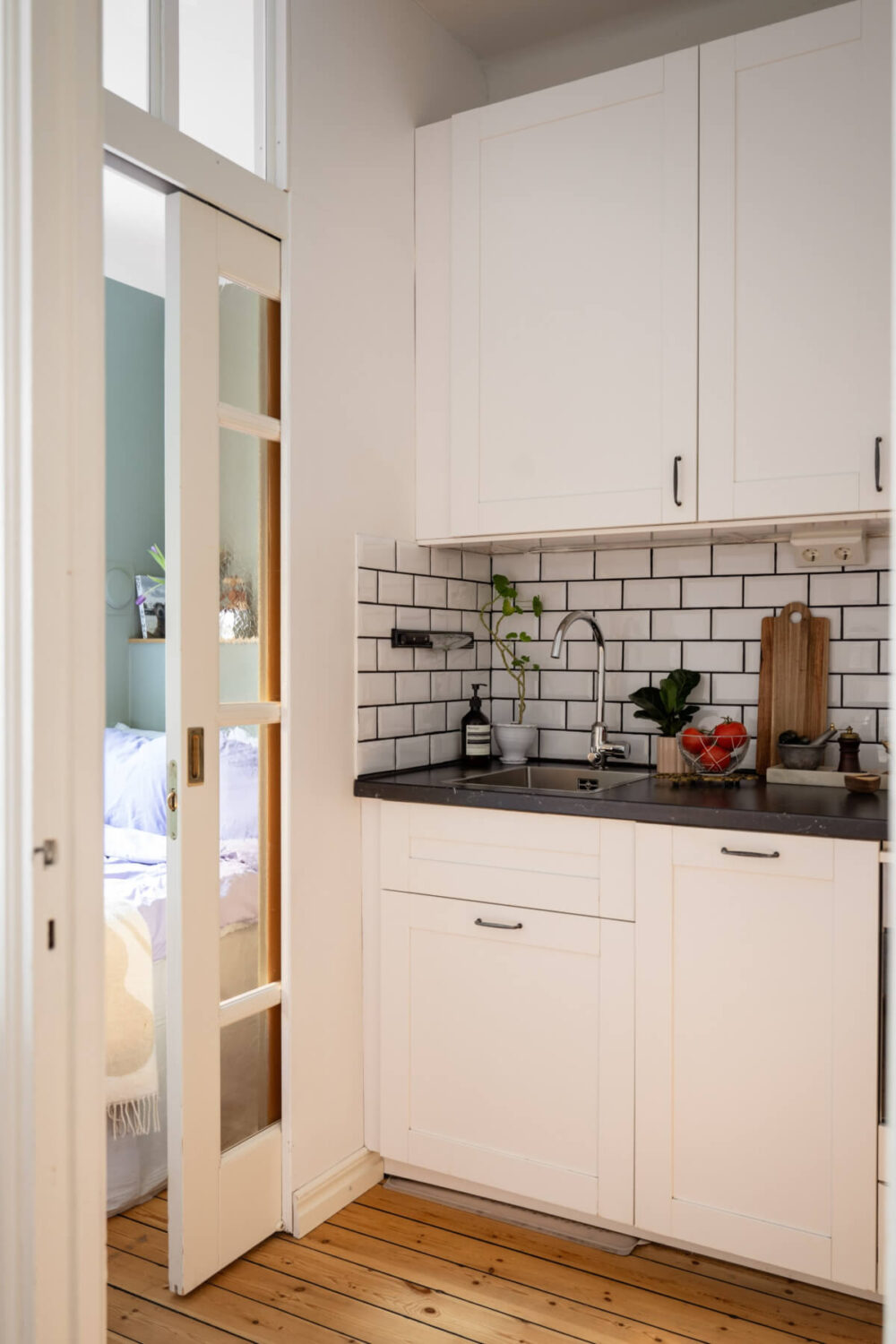 A Small Swedish Apartment with a Light Pink Living Room 12 tiny white kitchen glass sliding door
