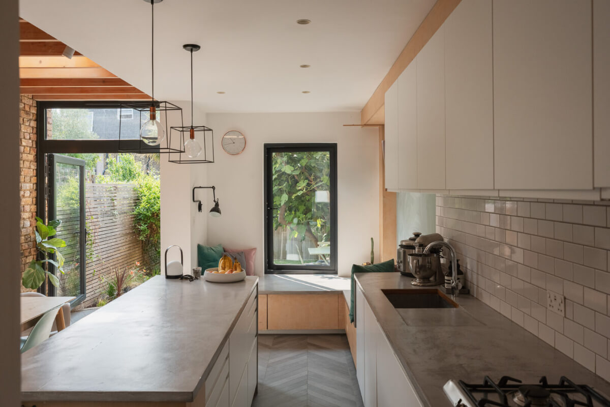 Exposed Brick and Wooden Beams in an Extended London Home 10 white kitchen concrete worktop window seat bench
