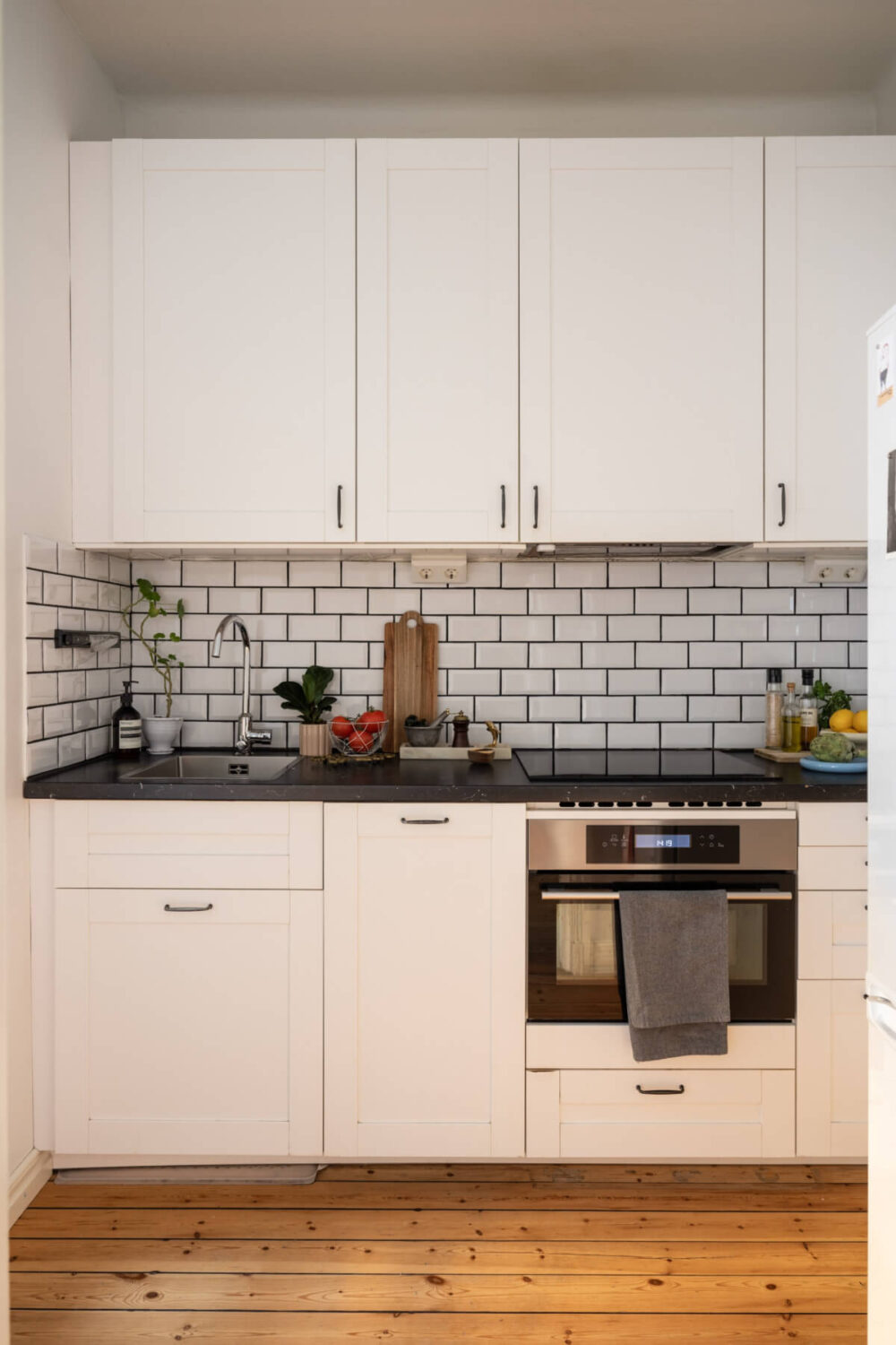 A Small Swedish Apartment with a Light Pink Living Room 11 white kitchen subway tiles