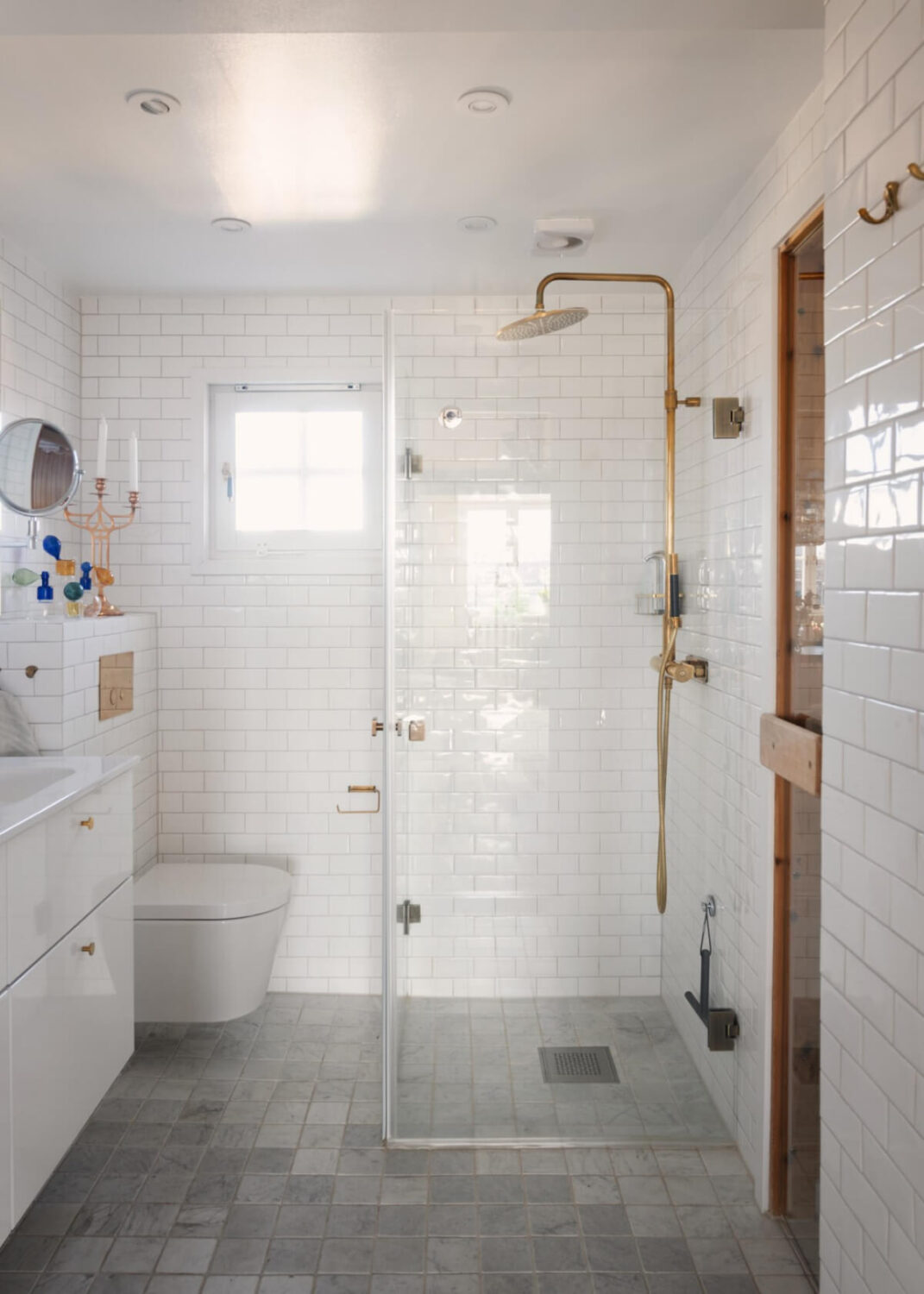 Revisiting a Spectacular Stockholm Penthouse with Exposed Beams 20 white tiles brass fittings bathroom