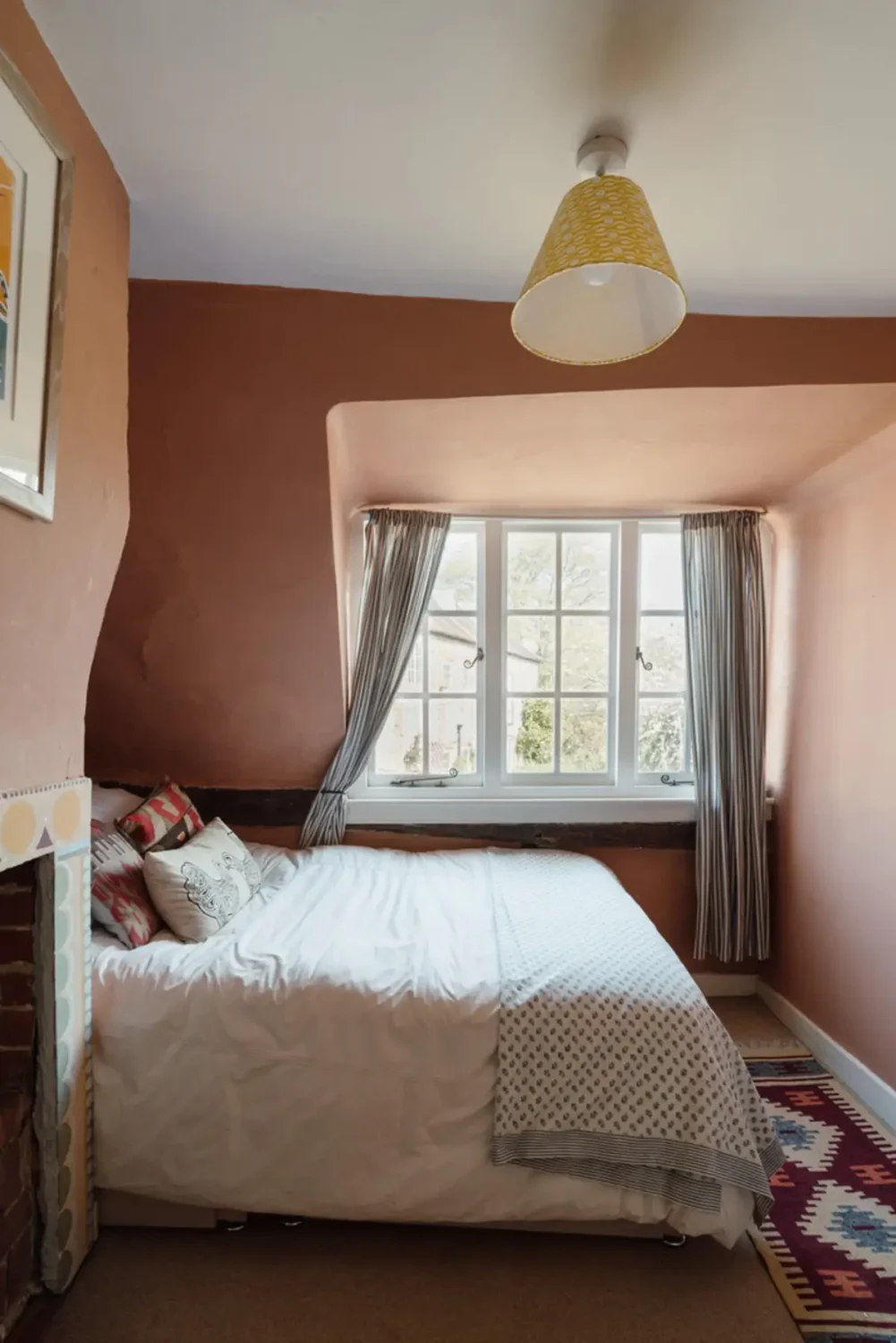 A Historic English Cottage Decorated in Pink & Blue Tones 17 cottage bedroom with fireplace and earthy pink walls