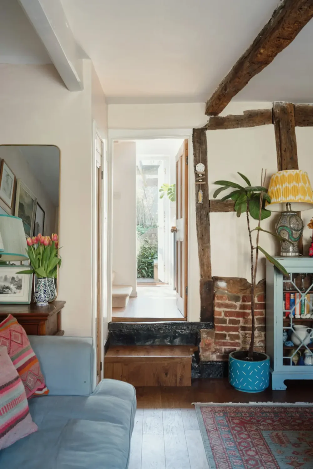A Historic English Cottage Decorated in Pink & Blue Tones 5 cottage living room exposed brick and beams