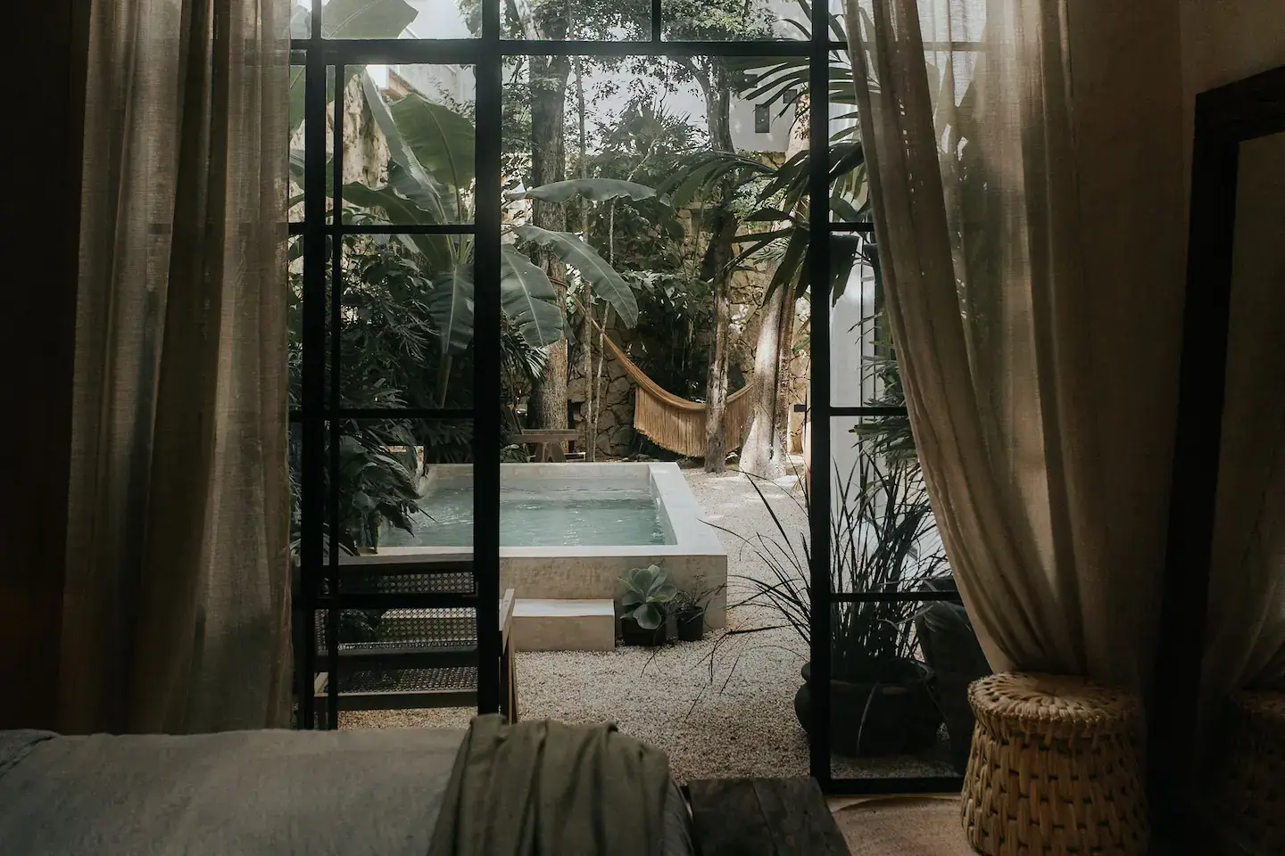 Rustic Wooden Elements in a Stylish Tulum Airbnb 21 steel-framed-glass-doors-bedroom-garden-swimming-pool-nordroom