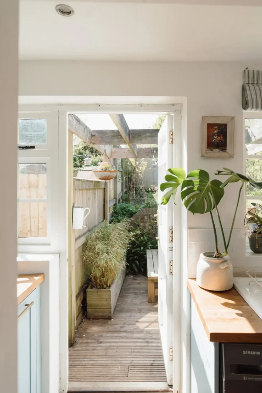 A Historic English Cottage Decorated in Pink & Blue Tones 9 view into garden